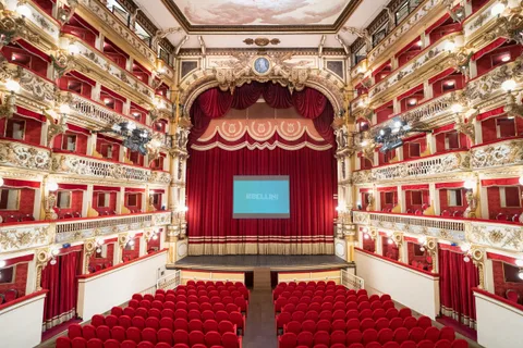 Interno del Teatro Bellini con il sipario rosso e i palchi decorati